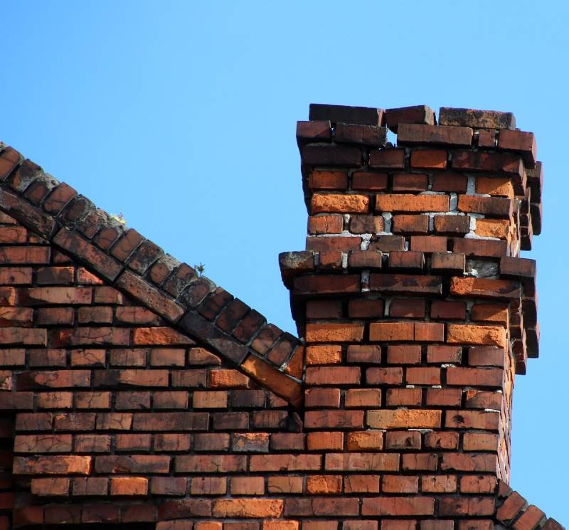 Damaged chimney on an Wixom home showing cracks and missing mortar